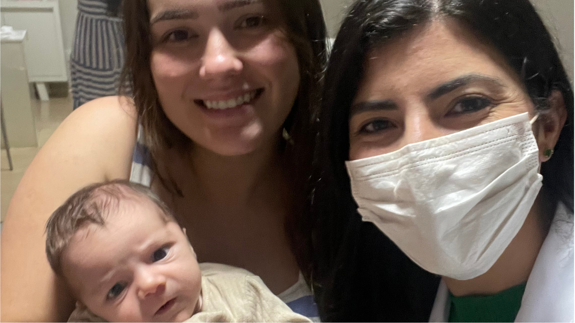 Mother holding baby beside Isabella Andrade